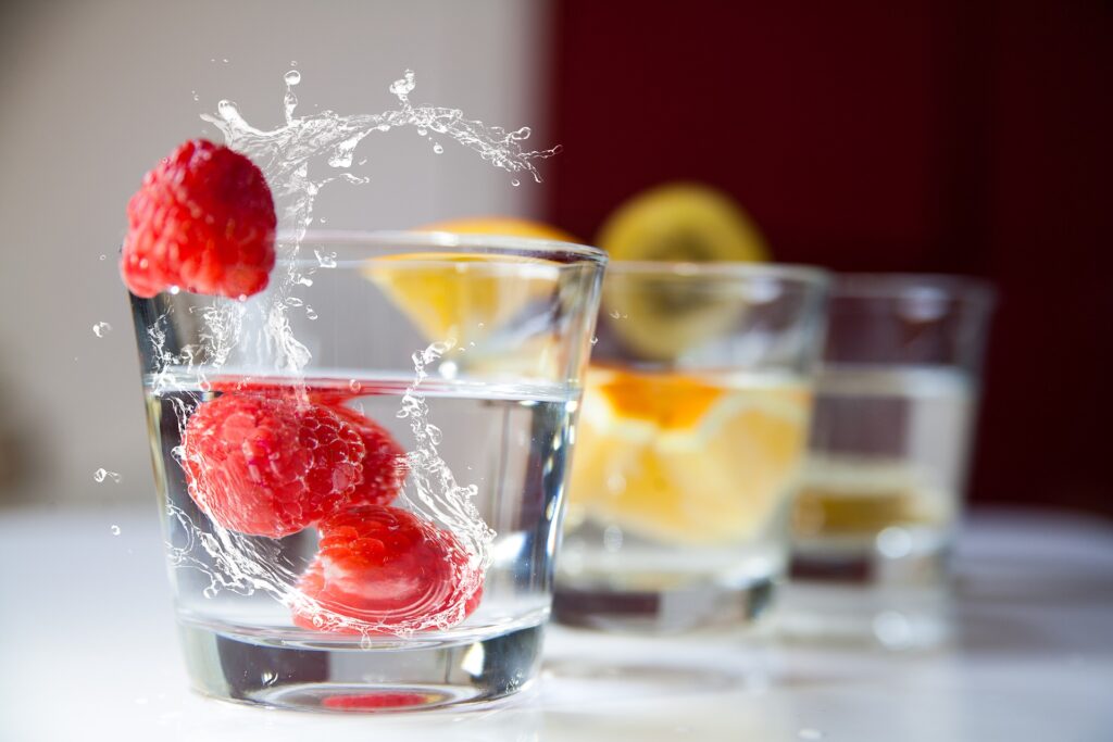 Tres vasos de agua saborizada con frutas coloridas
